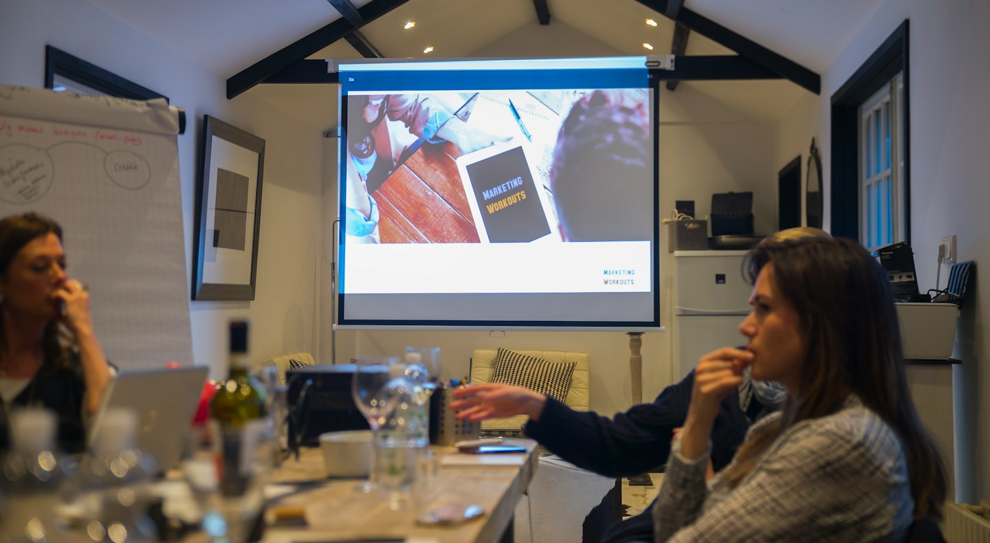 Business professionals attend a marketing workshop in a meeting room.